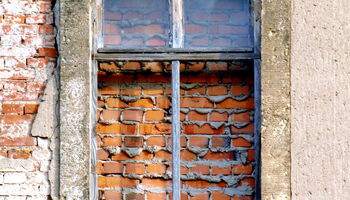 Vermauertes Fenster in alter Backsteinwand.