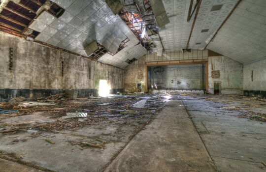 Einsturzgefährdete Halle mit kaputter Decke.